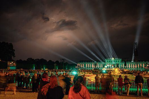 Vista del Palacio de Schoenbrunn, iluminado mientras la Orquesta Filarmónica de Viena actúa en el escenario durante el 'Concierto de la Noche de Verano' en Viena, Austria.