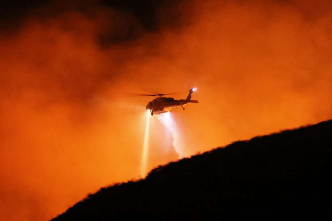 Un helicóptero lanza agua mientras arde el incendio Rabbit en Moreno Valley, en el condado californiano de Riverside, el 14 de julio de 2023.