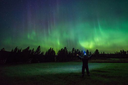 La aurora boreal más común es un arco o una banda verde que se alarga sobre el cielo.