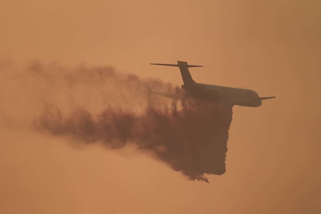 Un avión lanza retardante de incendios mientras los bomberos trabajan para controlar el Gavilan Fire, que ya ha quemado más de 100 hectáreas en Perris, condado de Riverside, California, el 15 de julio de 2023.
