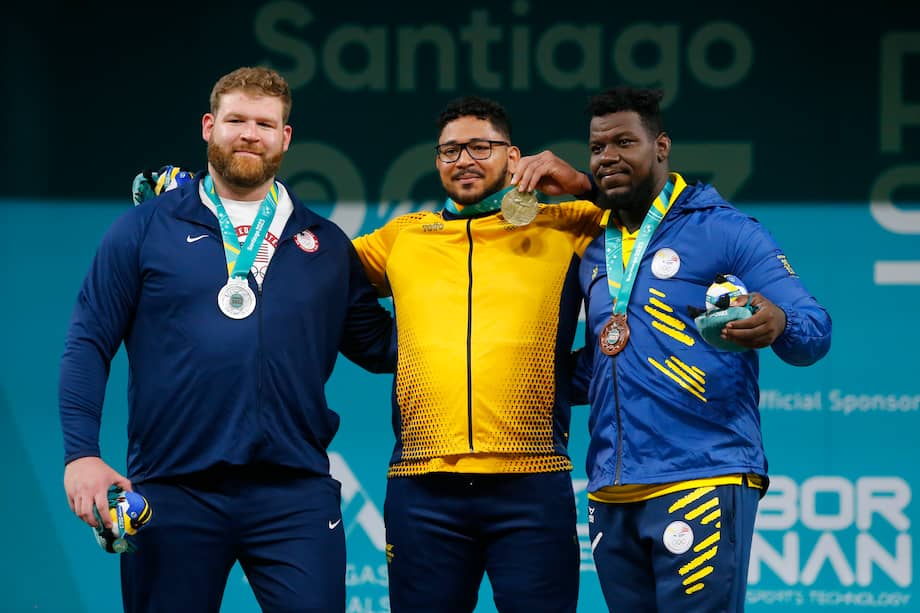 Rafael Cerro (cent.) de Colombia, medalla de oro, Keiser Witte (izq.) de los Estados Unidos, plata, y Dixon Arroyo de Ecuador, bronce, posan en el podio de levantamiento de pesas +102 kg masculino.