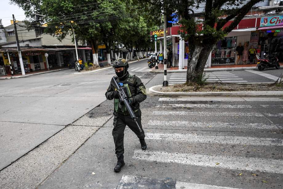 Un miembro de la Policía Nacional patrulla las calles de Saravena (Arauca), luego de que cinco personas fueran asesinadas en dos días, en medio del enfrentamiento disidencias de las Farc y el Eln. Cuatro municipios de Arauca conforman una de las 16 circunscripciones de paz. (Juan BARRETO / AFP). 