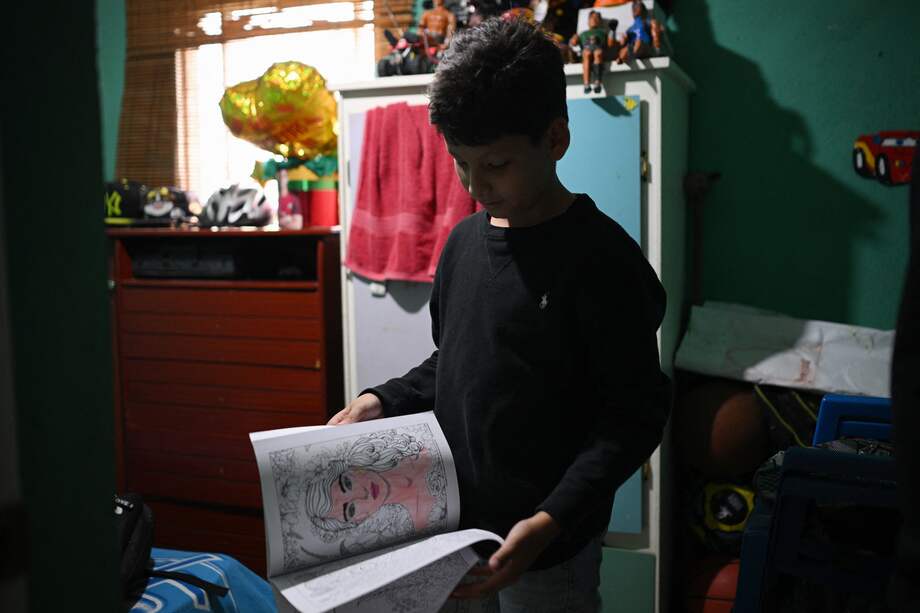 Randy Ordonez, estudiante venezolano, muestra uno de sus libros escoalres mientras se prepara los exámenes en Carabobo, Venezuela.