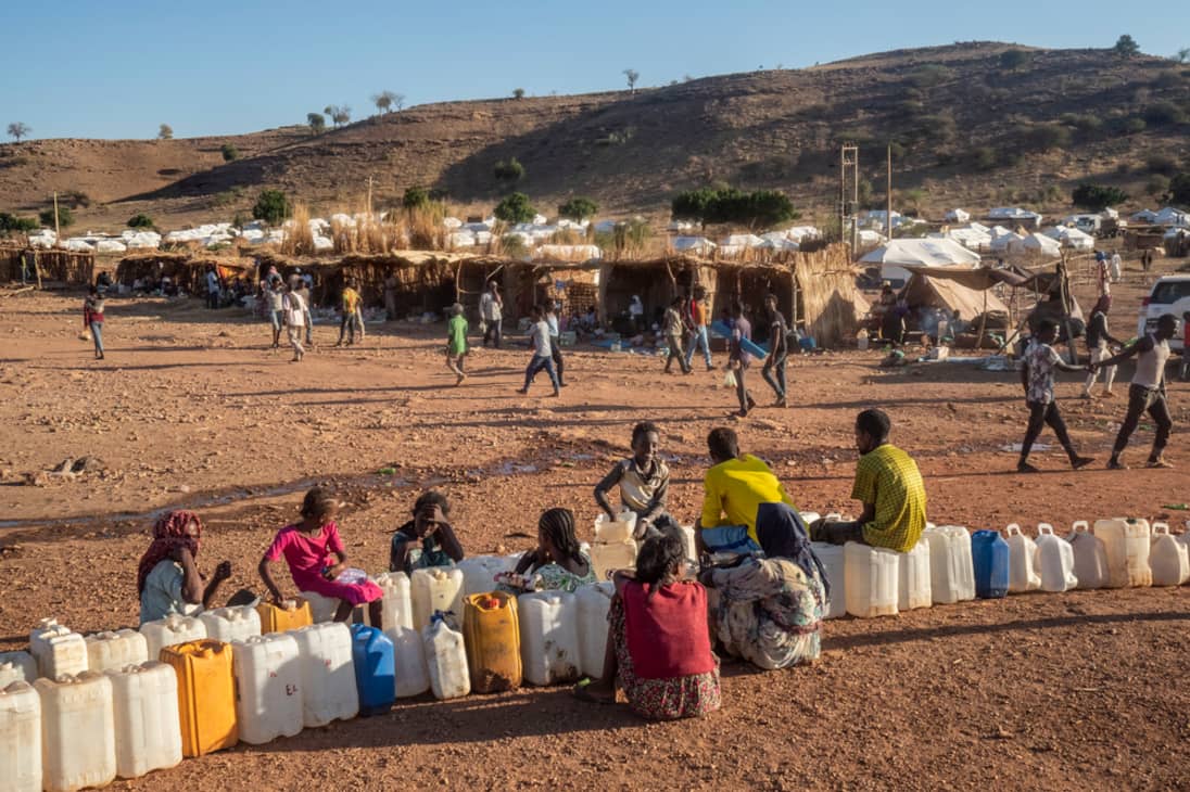 Refugiados esperan para cargar agua en bidones, en el campo de refugiados de Um Rakuba, ubicado en  Sudán, cerca de la frontera con la región etíope de Tigray.