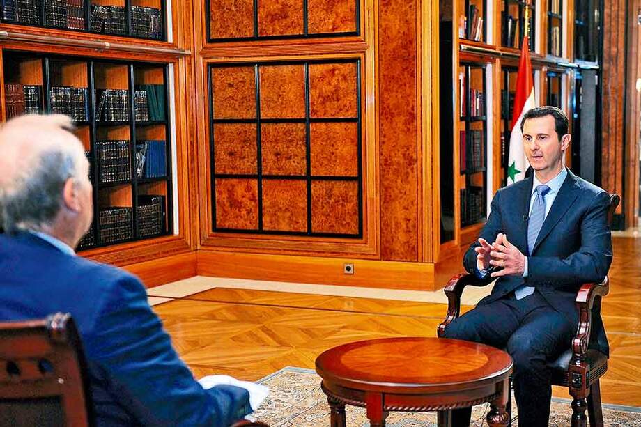 Bashar al Assad (der.), presidente de Siria, durante una entrevista en Damasco en la que aseguró que permanecerá en el poder después de la guerra civil. / AFP
