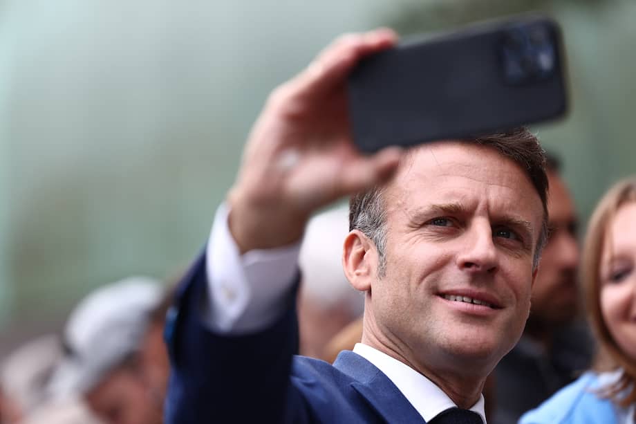 El presidente francés, Emmanuel Macron, se hace un selfie con un partidario después de votar en la primera vuelta de las elecciones parlamentarias francesas anticipadas.