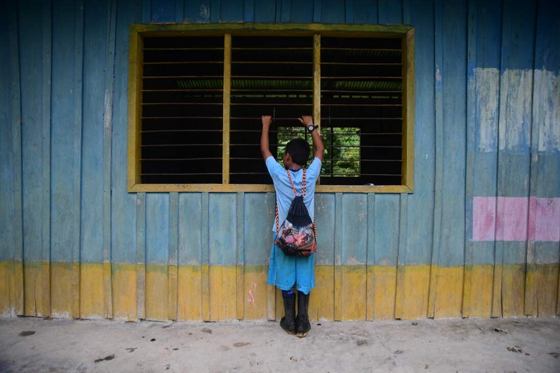 Un niño contempla una escuela abandonada en zona rural de Nóvita, Chocó. La región fue epicentro de combates continuos entre las Agc y el Eln durante todo el año 2022.