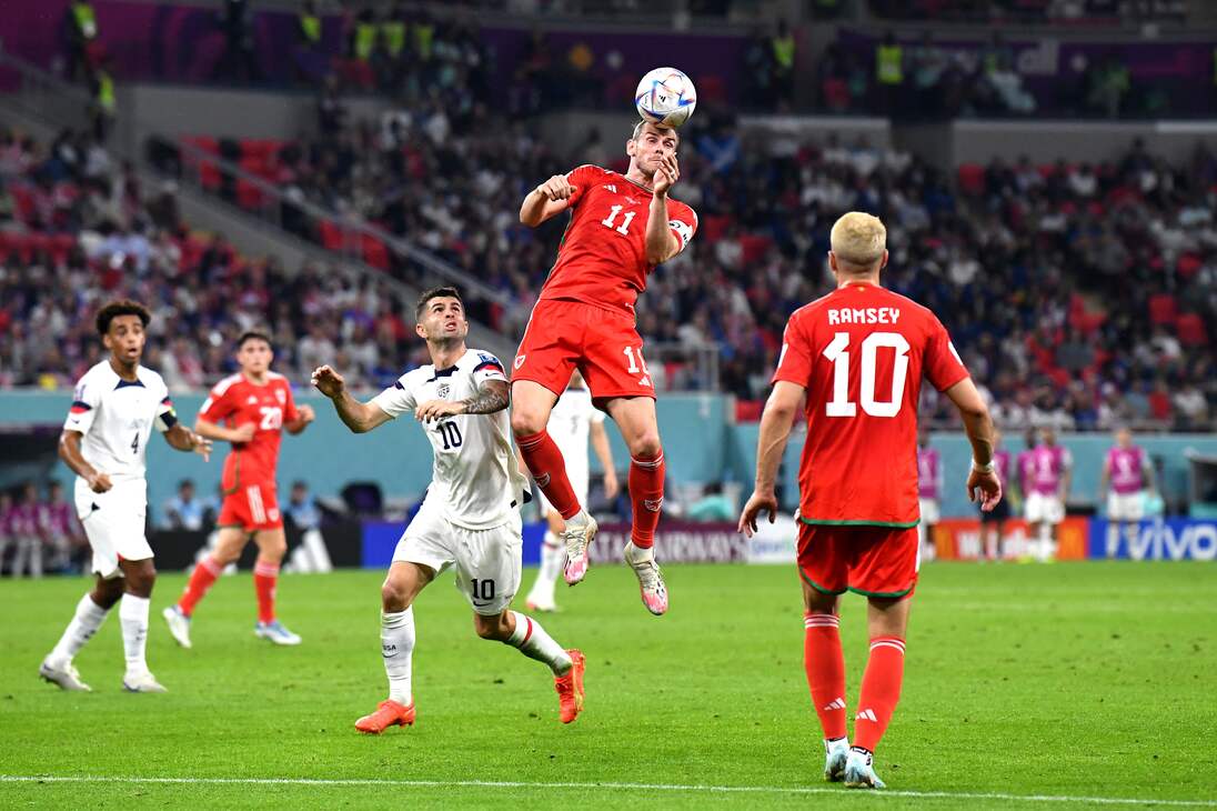 Doha (Qatar), 21/11/2022.- Gareth Bale (C) of Wales heads the ball in front of Christian Pulisic of the USA during the FIFA World Cup 2022 group B soccer match between the USA and Wales at Ahmad bin Ali Stadium in Doha, Qatar, 21 November 2022. (Mundial de Fútbol, Estados Unidos, Catar) EFE/EPA/Neil Hall