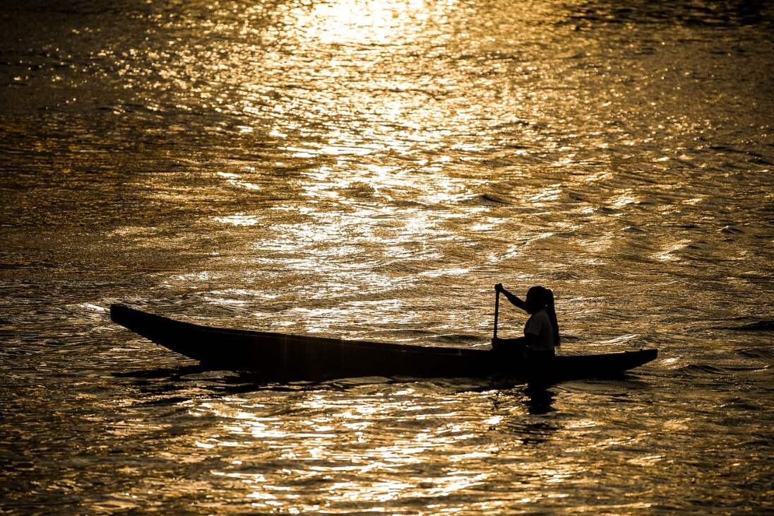 Una mujer indígena navega el río Vaupés, al caer la tarde. Una región en la que hoy sus habitantes trabajan para que muchas personas conozcan este destino que años atrás fue azotado por la violencia del conflicto armado.