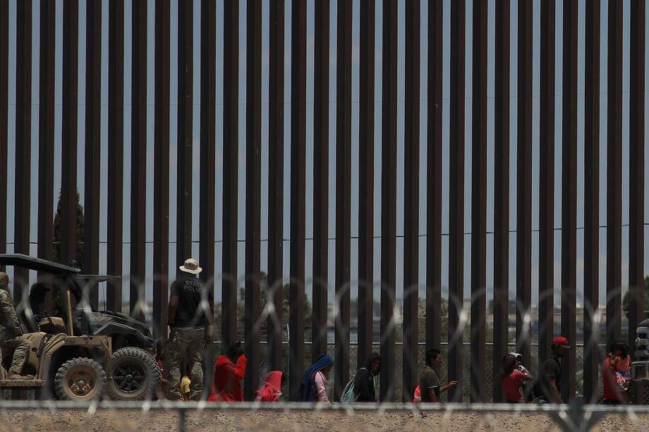 Policías de la Guardia Nacional de Texas dialogan por medio de altavoces con migrantes este viernes, en el muro que divide a México con Estados Unidos, en Ciudad Juárez (México). 