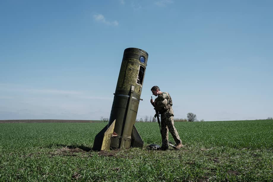 Un militar ucraniano mira una parte de un misil balístico ruso que cayó en un campo en Bohodarove, este de Ucrania, el 25 de abril de 2022, en medio de la invasión rusa de Ucrania.