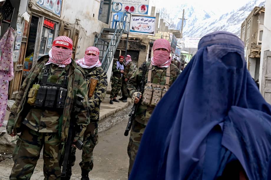 Imagen de referencia. Personal de seguridad talibán monta guardia mientras una mujer afgana vestida con burka camina por una calle de un mercado del distrito de Baharak, en la provincia de Badakhshan, Afganistán.